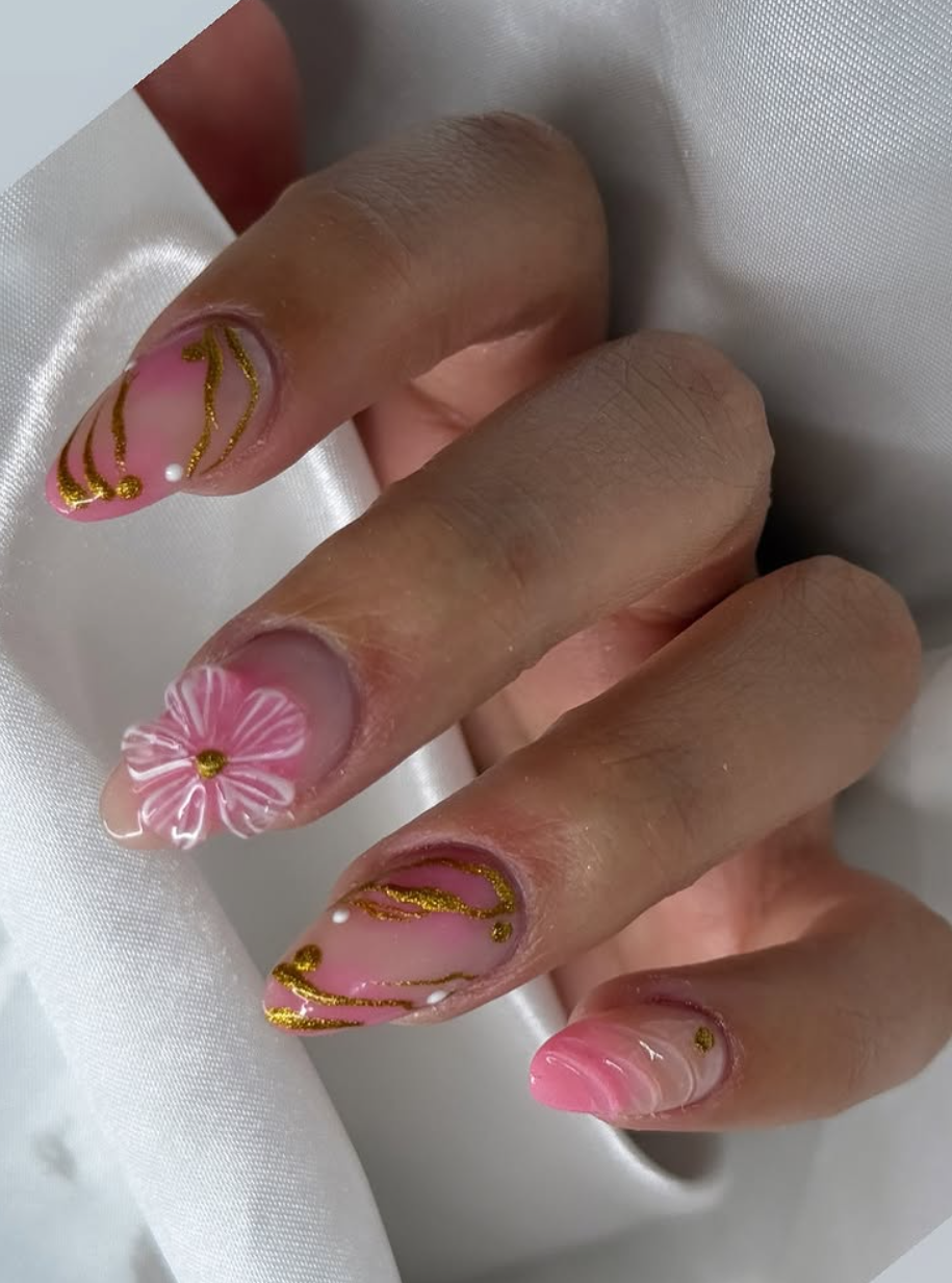 Uñas rosas con mariposa dorada y detalles florales